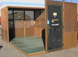 A walk-in screen room: a room-sized shielded enclosure with panelled copper-coloured walls, a raised floor and a heavy gasketed door