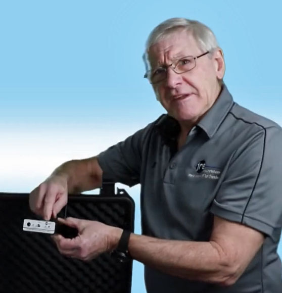 John Ramsey holding a JRE filtered I/O interface beside an open enclosure